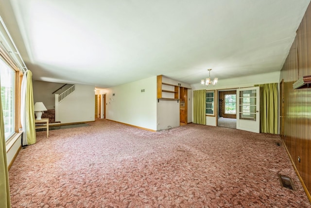 4N051 Wood Dale Rd, Addison, IL 60101 - unfurnished living room with a chandelier, carpet, and stairs