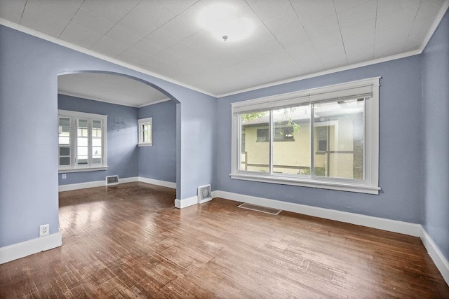 8 Manor Ct, Joliet, IL 60436 - empty room with ornamental molding, arched walkways, healthy amount of natural light, wood finished floors, and baseboards
