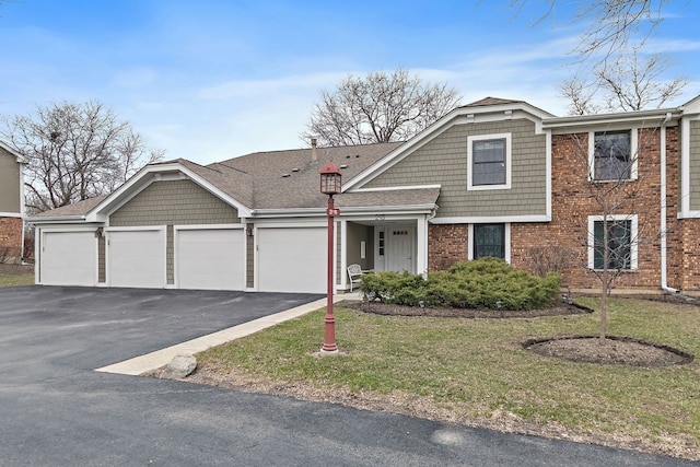 218 Deerpath Ct Unit B2, Schaumburg, IL 60193 - view of front of home featuring driveway, a front yard, an attached garage, and brick siding