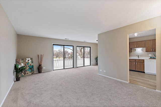 218 Deerpath Ct Unit B2, Schaumburg, IL 60193 - unfurnished living room featuring light colored carpet, baseboards, and a sink