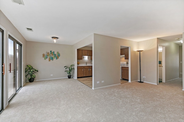 218 Deerpath Ct Unit B2, Schaumburg, IL 60193 - unfurnished living room with light carpet, a sink, and baseboards
