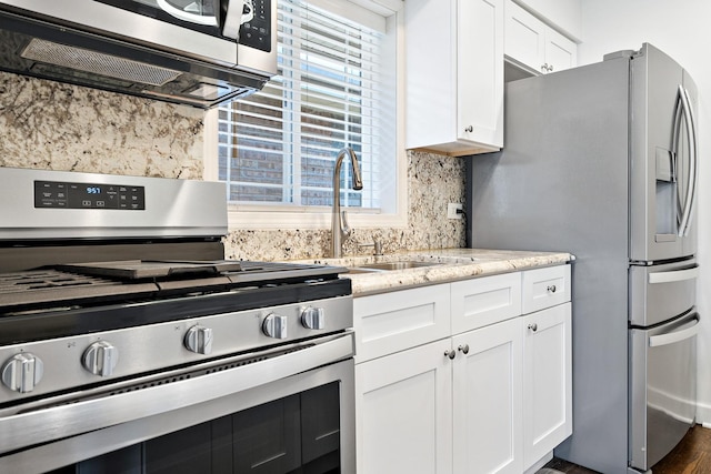 5708 W 82nd Pl, Burbank, IL 60459 - kitchen featuring appliances with stainless steel finishes, backsplash, light stone countertops, white cabinetry, and a sink