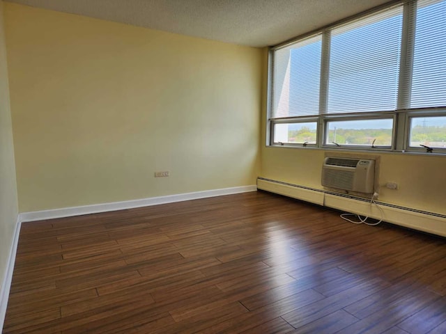 8815 W Golf Rd Unit 6B, Niles, IL 60714 - spare room with baseboards, dark wood-style flooring, a textured ceiling, a wall unit AC, and baseboard heating