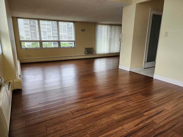 8815 W Golf Rd Unit 6B, Niles, IL 60714 - empty room with wood-type flooring, an AC wall unit, a baseboard radiator, a textured ceiling, and baseboards