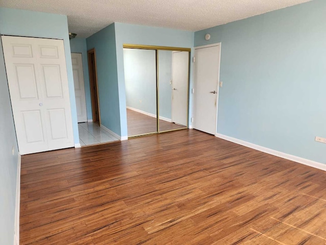8815 W Golf Rd Unit 6B, Niles, IL 60714 - unfurnished bedroom featuring wood finished floors, a textured ceiling, and baseboards