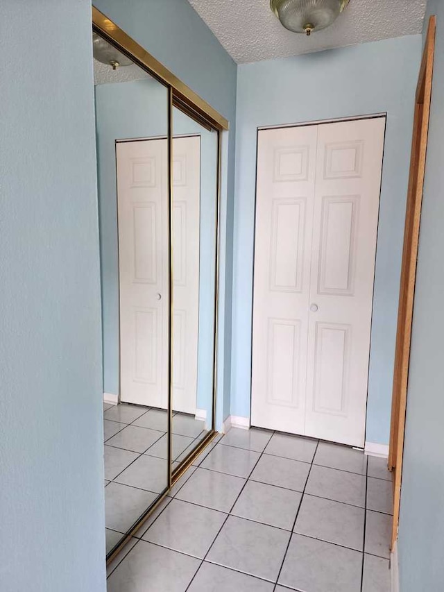 8815 W Golf Rd Unit 6B, Niles, IL 60714 - hallway featuring a textured ceiling and light tile patterned floors