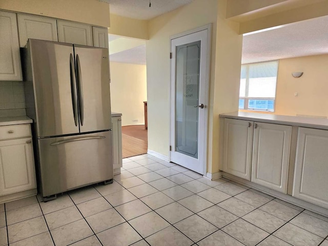 8815 W Golf Rd Unit 6B, Niles, IL 60714 - kitchen featuring freestanding refrigerator, light countertops, light tile patterned floors, baseboards, and tasteful backsplash