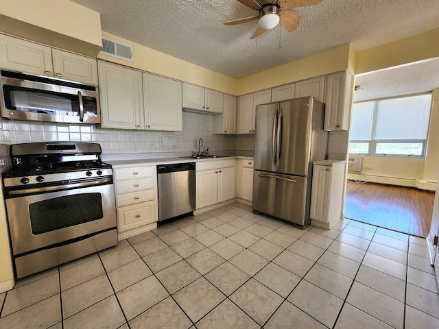 8815 W Golf Rd Unit 6B, Niles, IL 60714 - kitchen with stainless steel appliances, a sink, a textured ceiling, light countertops, and a ceiling fan