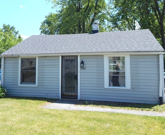 2406 Grape St, Joliet, IL 60435 - view of front of home with a chimney, a front yard, and roof with shingles