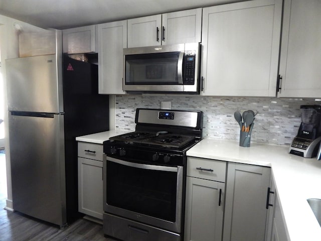 2406 Grape St, Joliet, IL 60435 - kitchen with appliances with stainless steel finishes, light countertops, dark wood-style floors, and tasteful backsplash