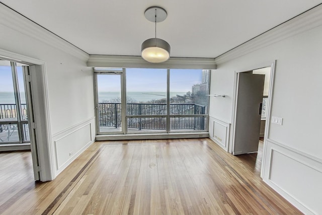 1040 N Lake Shore Dr Unit 7B, Chicago, IL 60611 - empty room with a decorative wall, ornamental molding, a water view, light wood-style flooring, and a wainscoted wall