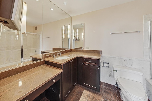 1040 N Lake Shore Dr Unit 7B, Chicago, IL 60611 - bathroom featuring toilet, tiled shower, vanity, tile walls, and a wainscoted wall