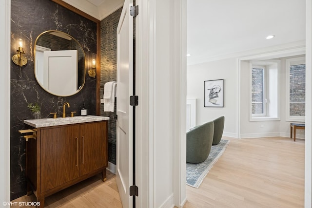 4256 N Keeler Ave, Chicago, IL 60641 - bathroom with vanity, baseboards, wood finished floors, an accent wall, and recessed lighting