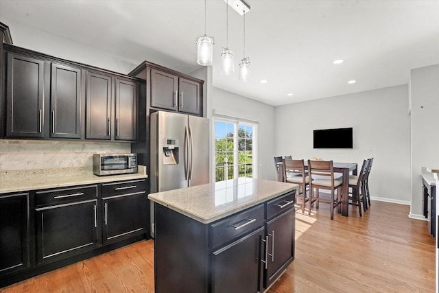 525 Plaza Pl, Aurora, IL 60504 - kitchen featuring light wood-style flooring, hanging light fixtures, light stone countertops, a kitchen island, and recessed lighting