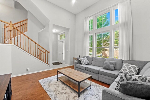 525 Plaza Pl, Aurora, IL 60504 - living room featuring a high ceiling, plenty of natural light, stairway, wood finished floors, and baseboards