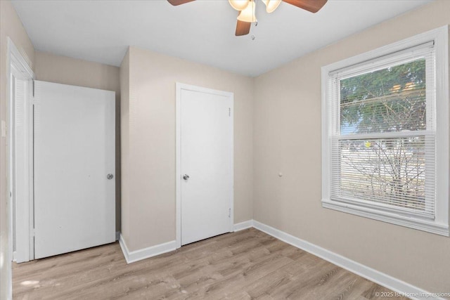 3231 W 99th St, Evergreen Park, IL 60805 - unfurnished bedroom with light wood finished floors, baseboards, ceiling fan, and a closet