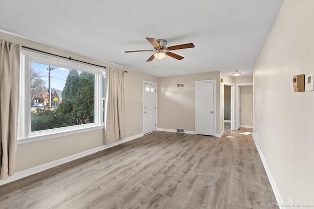 3231 W 99th St, Evergreen Park, IL 60805 - unfurnished living room featuring ceiling fan, light wood finished floors, and baseboards