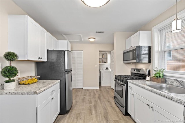 3231 W 99th St, Evergreen Park, IL 60805 - kitchen featuring stainless steel appliances, a sink, washer / clothes dryer, white cabinetry, and light wood finished floors