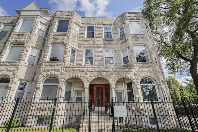 6557 S University Ave Unit 204, Chicago, IL 60637 - view of front facade with a fenced front yard, stone siding, and a gate