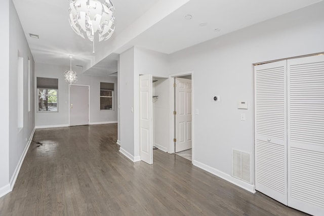 6557 S University Ave Unit 204, Chicago, IL 60637 - unfurnished living room with a chandelier, dark wood finished floors, and baseboards