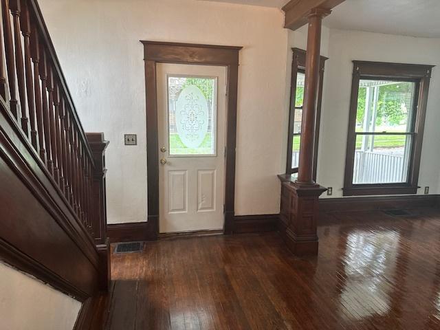 509 N Quincy St, Clinton, IL 61727 - entryway featuring ornate columns, dark wood-style flooring, stairway, and baseboards
