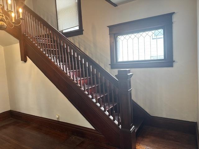 509 N Quincy St, Clinton, IL 61727 - stairs featuring wood finished floors, a chandelier, and baseboards