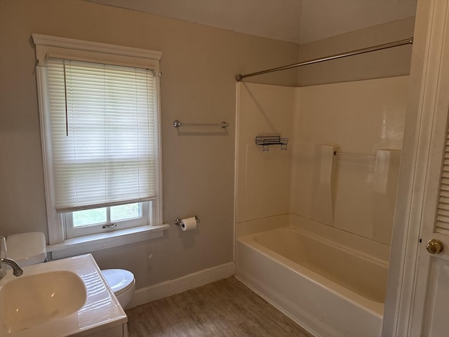 509 N Quincy St, Clinton, IL 61727 - bathroom with toilet, baseboards,  shower combination, wood finished floors, and vanity