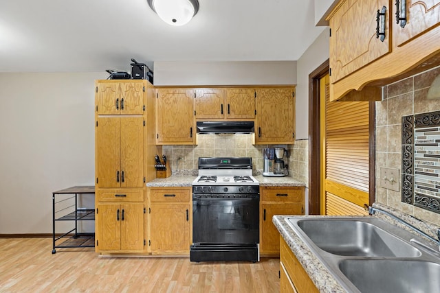 8517 Steven Pl Unit 4, Tinley Park, IL 60477 - kitchen with gas range oven, under cabinet range hood, a sink, decorative backsplash, and light wood finished floors
