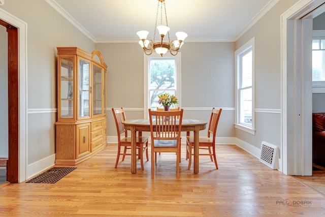 71 S Chestnut St, Aurora, IL 60506 - dining space with healthy amount of natural light, light wood finished floors, ornamental molding, and a chandelier
