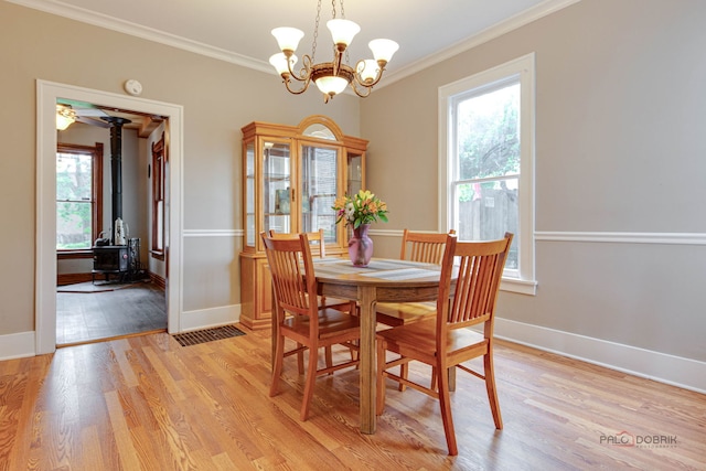 71 S Chestnut St, Aurora, IL 60506 - dining area with a wood stove, healthy amount of natural light, light wood-style floors, crown molding, and a chandelier