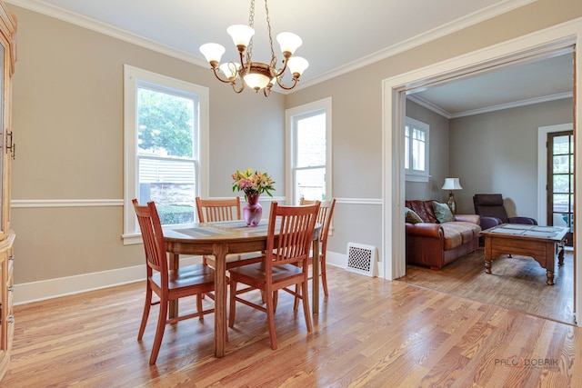 71 S Chestnut St, Aurora, IL 60506 - dining room featuring light wood-style floors, plenty of natural light, a chandelier, and crown molding