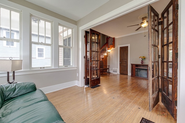 71 S Chestnut St, Aurora, IL 60506 - living room featuring stairway, light wood finished floors, baseboards, a ceiling fan, and plenty of natural light