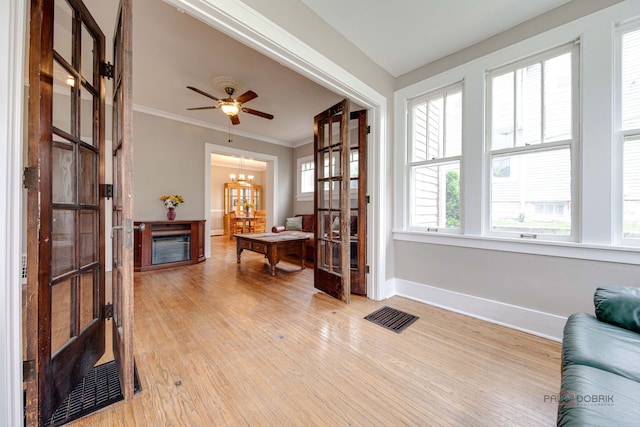 71 S Chestnut St, Aurora, IL 60506 - living area with light wood-style flooring, baseboards, a fireplace, crown molding, and a chandelier