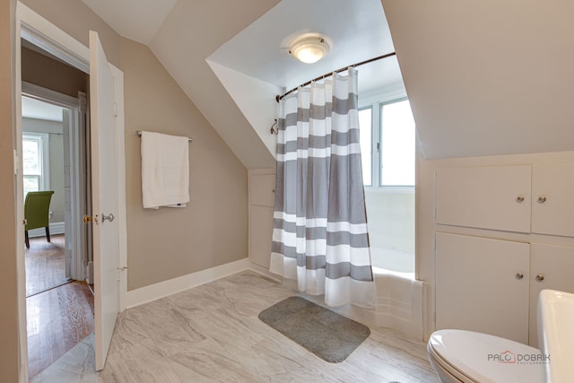 71 S Chestnut St, Aurora, IL 60506 - full bathroom featuring vaulted ceiling, toilet, marble look tiles, and shower / tub combo with curtain