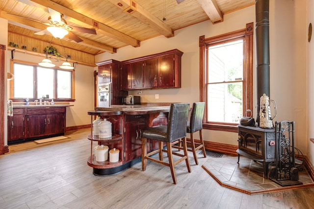 71 S Chestnut St, Aurora, IL 60506 - kitchen featuring a wood stove, wood ceiling with exposed beams, baseboards, oven, and a ceiling fan
