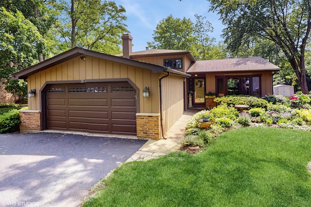 26W029 Hazel Ln, Wheaton, IL 60187 - view of front of house with a chimney, an attached garage, brick siding, driveway, and a front yard