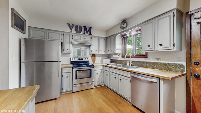 26W029 Hazel Ln, Wheaton, IL 60187 - kitchen featuring stainless steel appliances, under cabinet range hood, light wood finished floors, and wood counters