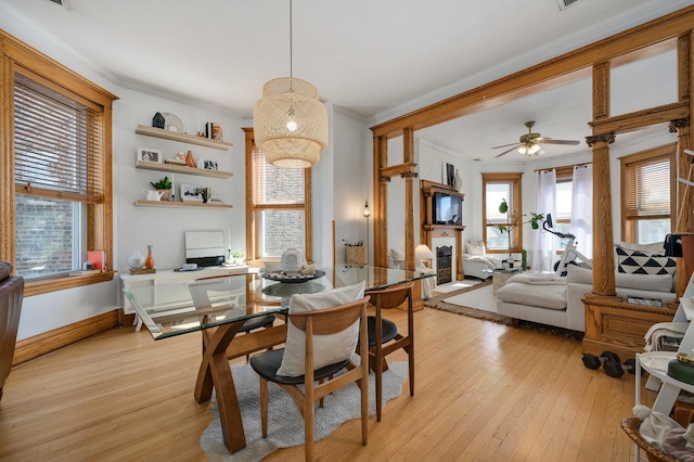 2533 N Kimball Ave, Chicago, IL 60647 - dining room with a glass covered fireplace, light wood finished floors, crown molding, ceiling fan, and baseboards