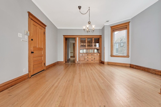 2533 N Kimball Ave, Chicago, IL 60647 - unfurnished room with a chandelier, ornamental molding, light wood-style floors, and baseboards
