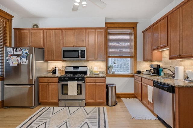 2533 N Kimball Ave, Chicago, IL 60647 - kitchen featuring stainless steel appliances, light wood-type flooring, light stone countertops, backsplash, and crown molding