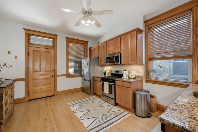 2533 N Kimball Ave, Chicago, IL 60647 - kitchen featuring stainless steel appliances, baseboards, light wood-style flooring, decorative backsplash, and healthy amount of natural light