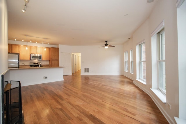 1500 S Halsted St Unit 1B, Chicago, IL 60607 - unfurnished living room featuring track lighting, ceiling fan, light wood-style flooring, and baseboards