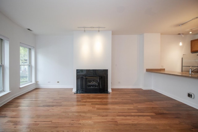 1500 S Halsted St Unit 1B, Chicago, IL 60607 - unfurnished living room featuring rail lighting, wood finished floors, and a sink