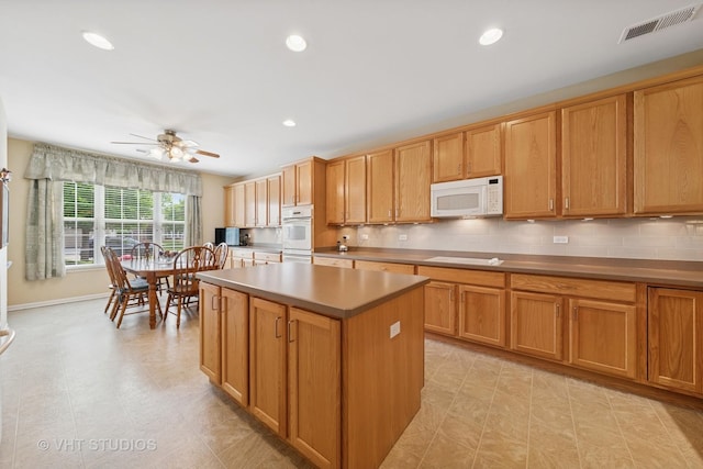 319 Capital Dr, Shorewood, IL 60404 - kitchen with white microwave, a kitchen island, a ceiling fan, backsplash, and recessed lighting