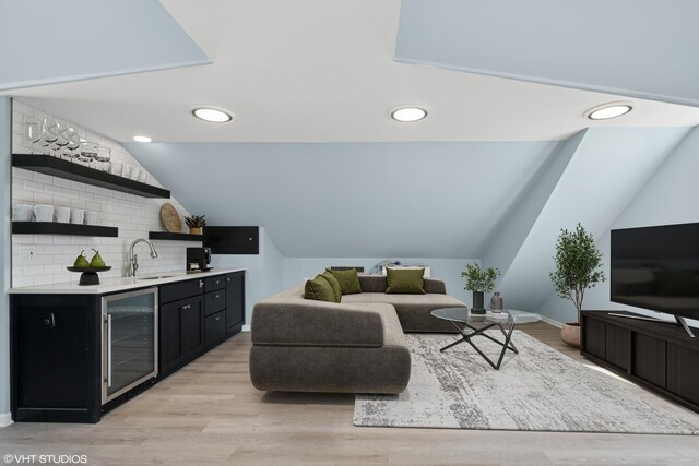 1225 Morgan Ave, La Grange Park, IL 60526 - living area featuring beverage cooler, bar with sink, vaulted ceiling, light wood-style flooring, and baseboards