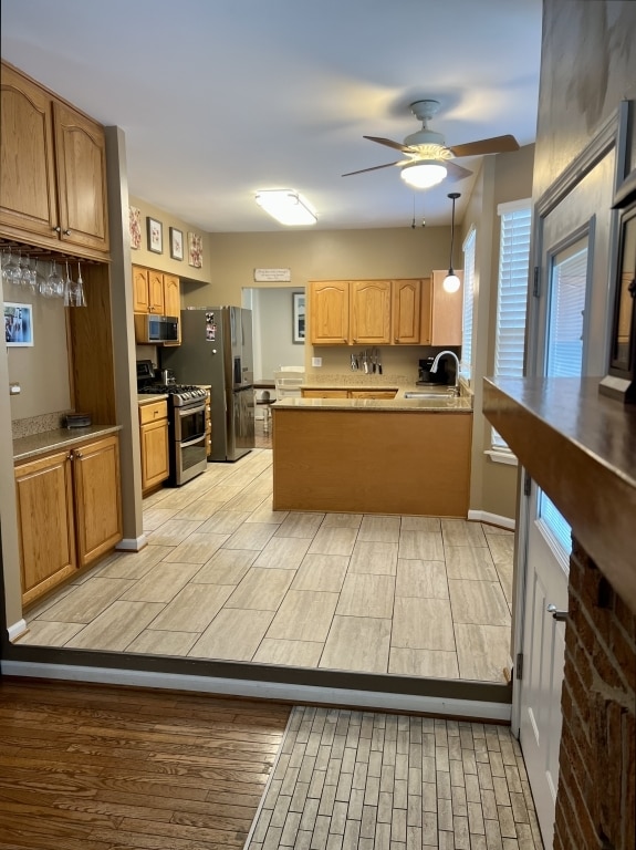 7 Ivy Ct, South Elgin, IL 60177 - kitchen with appliances with stainless steel finishes, a ceiling fan, a peninsula, and hanging light fixtures