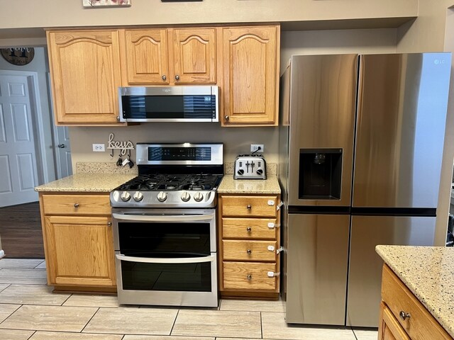 7 Ivy Ct, South Elgin, IL 60177 - kitchen with stainless steel appliances, light stone countertops, wood tiled floors, and light brown cabinetry
