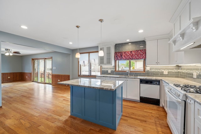 8862 167th St, Orland Hills, IL 60487 - kitchen with white appliances, a sink, a kitchen island, white cabinets, and a wainscoted wall