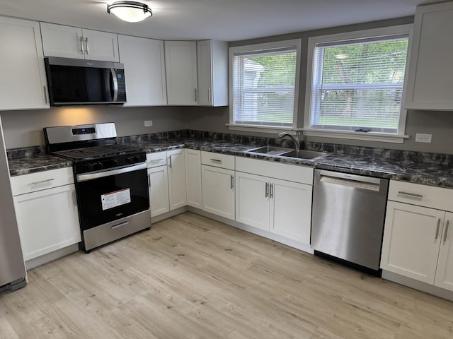 2407 Burbank St, Joliet, IL 60435 - kitchen with stainless steel appliances, a sink, light wood-style floors, and dark stone counters