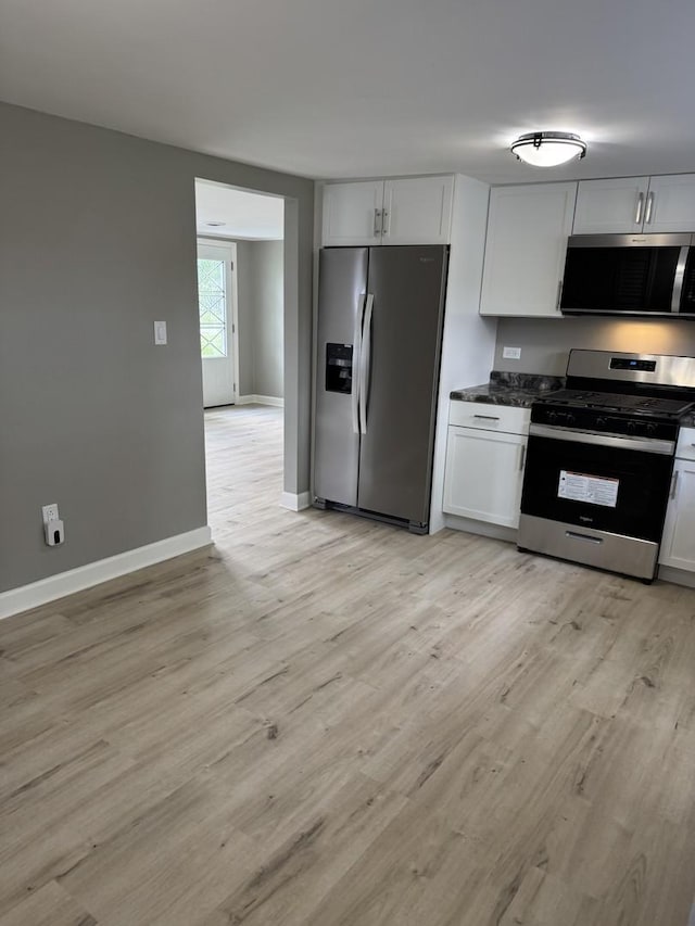 2407 Burbank St, Joliet, IL 60435 - kitchen with stainless steel appliances, light wood-style floors, white cabinets, baseboards, and dark stone countertops